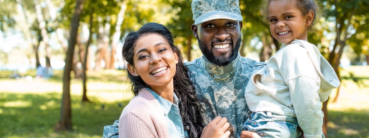 Happy,African,American,Soldier,In,Military,Uniform,Looking,At,Camera happy african american soldier in military uniform looking at camera with family in park